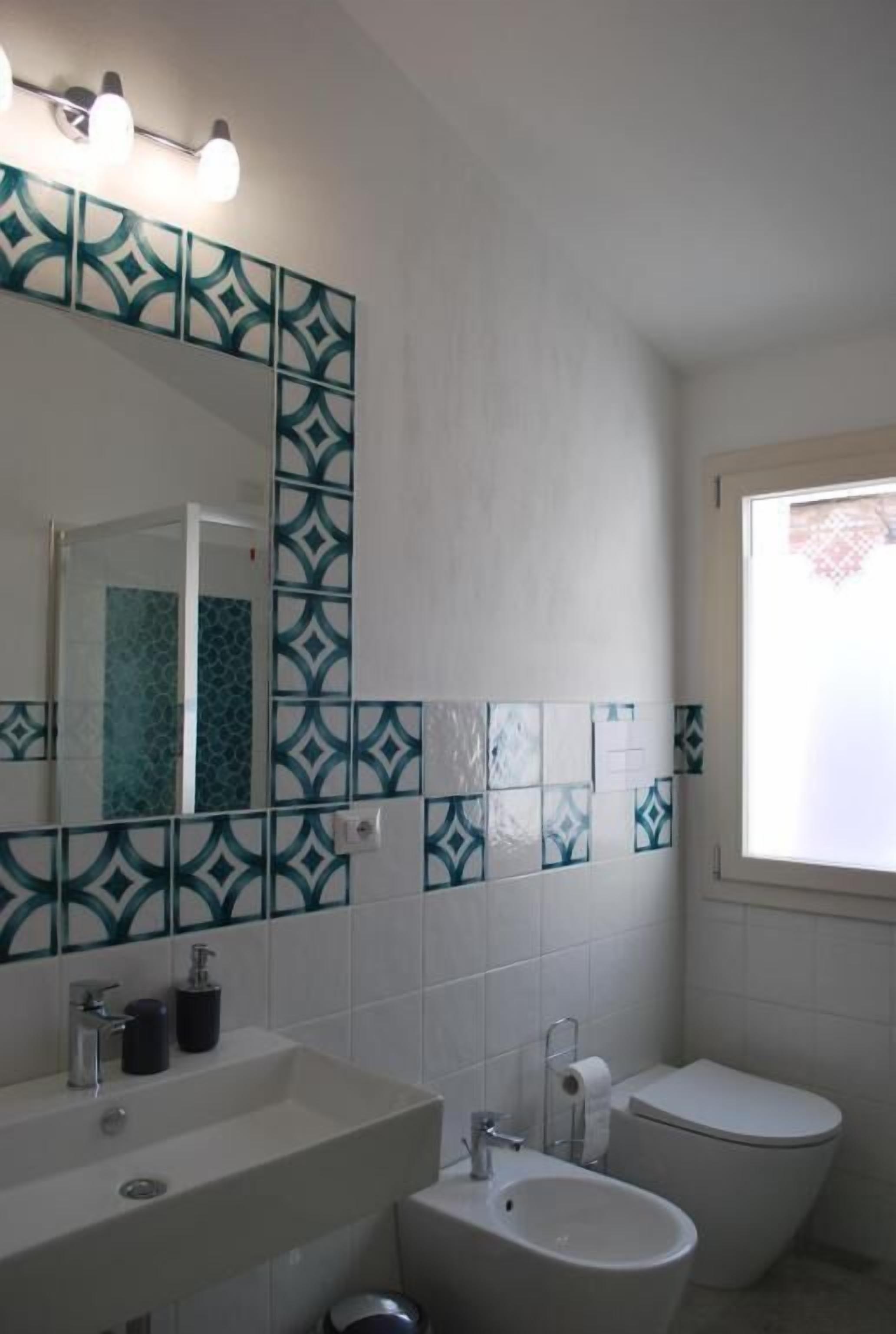 A bathroom with a sink, bidet, and toilet.