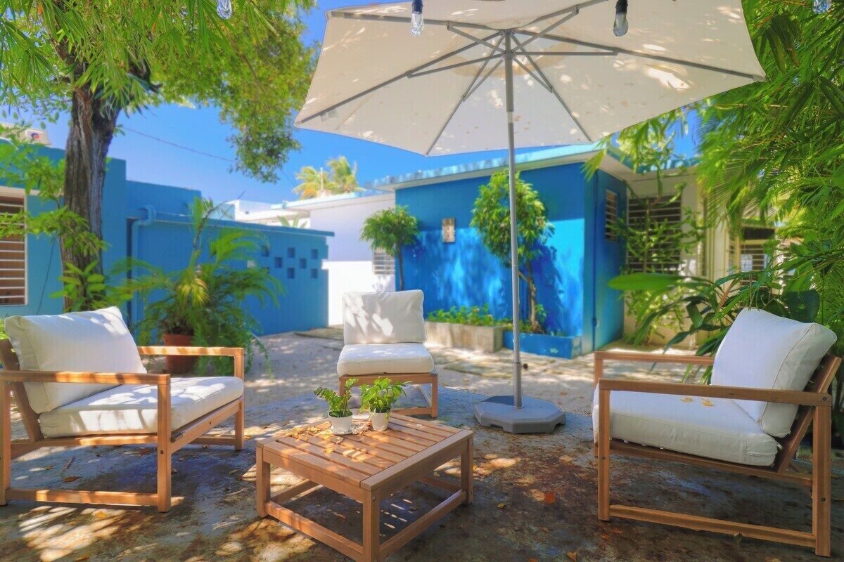 An outdoor seating area with wooden furniture and a large umbrella.