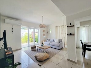Un salon moderne comprenant un canapé, une table basse et un coin repas avec une table et des chaises.
