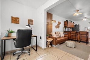 Una cocina moderna con armarios de madera, un refrigerador y un comedor con taburetes de bar.