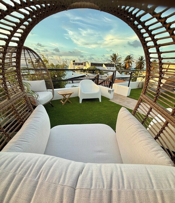 A circular seating area with a view of a pool and buildings.