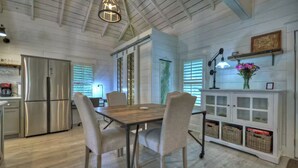 A modern kitchen with a stainless steel refrigerator, a dining table with chairs, and a white cabinet with baskets. - Memory Maker, Top of GA Cottage in charming Mineral Bluff with AC, WiFi (Mineral Bluff)