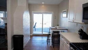 A kitchen with a stove, sink, and bar stools. - Spacious Vermilion House on the Lake (Vermilion)