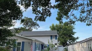 A single-story house with a front porch, a small garden, and a wooden fence. - Spacious Vermilion House on the Lake (Vermilion)