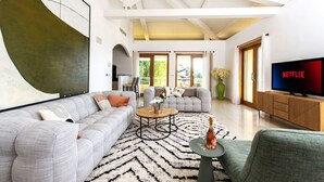 A spacious living room with a large grey sofa, a coffee table, and a TV displaying 'NETFLIX'. - Magnificent sea view villa - DG (Cap-d'Ail)