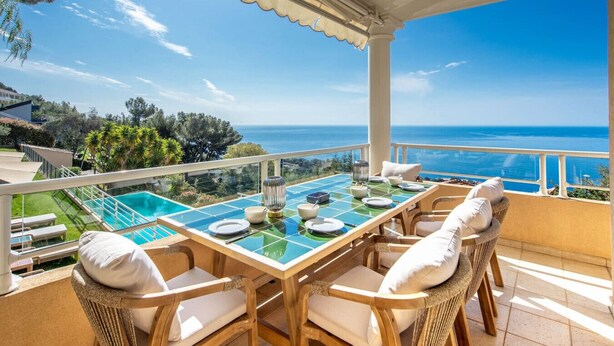 A terrace with a table set for dining, overlooking a swimming pool and the sea. - Magnificent sea view villa - DG (Cap-d'Ail)