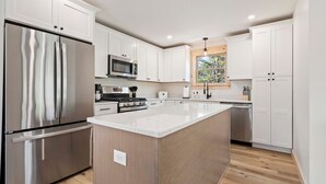 A modern kitchen with white cabinetry, stainless steel appliances, and a central island. - Pointers Den-Fireplace, Arcade, 2 Primary Suites (Bethel)