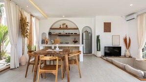 A modern kitchen with an archway leading to a dining area. - Luxurious 2BR Villa - Scenic Rice Field Views - Beautiful Swimming Pool & Garden (Canggu)