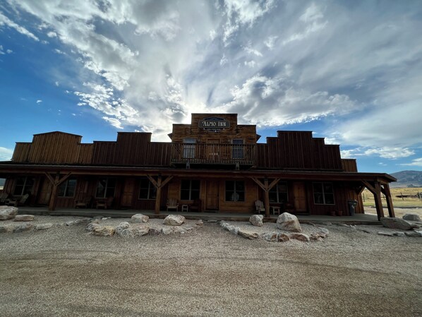 A rustic wooden building with a sign reading "Alto Inn."