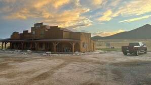 Un bâtiment rustique en bois, doté d’un porche, d’une enseigne indiquant « Alamo Inn » et d’un camion garé devant.