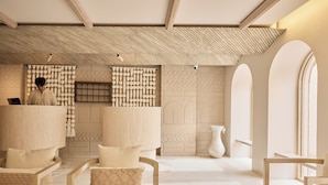 Un cuarto de spa con techo de madera, una recepción y una zona de estar con un jarrón grande.