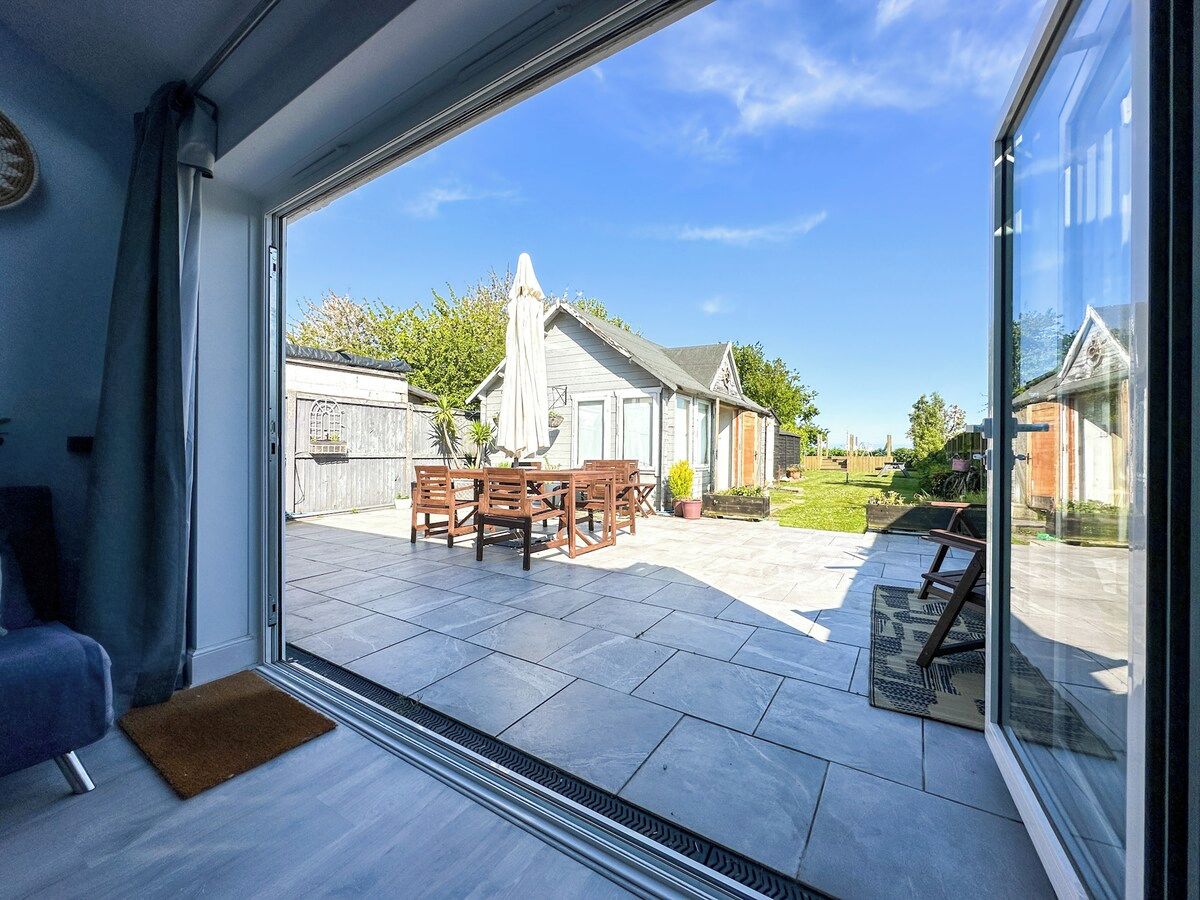 A room with a sliding glass door leading to an outdoor patio area with a table and chairs.