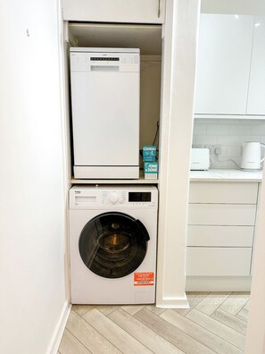 A compact laundry area with a washing machine and dryer stacked vertically.