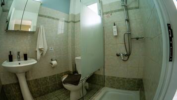 A bathroom with a sink, toilet, and shower.