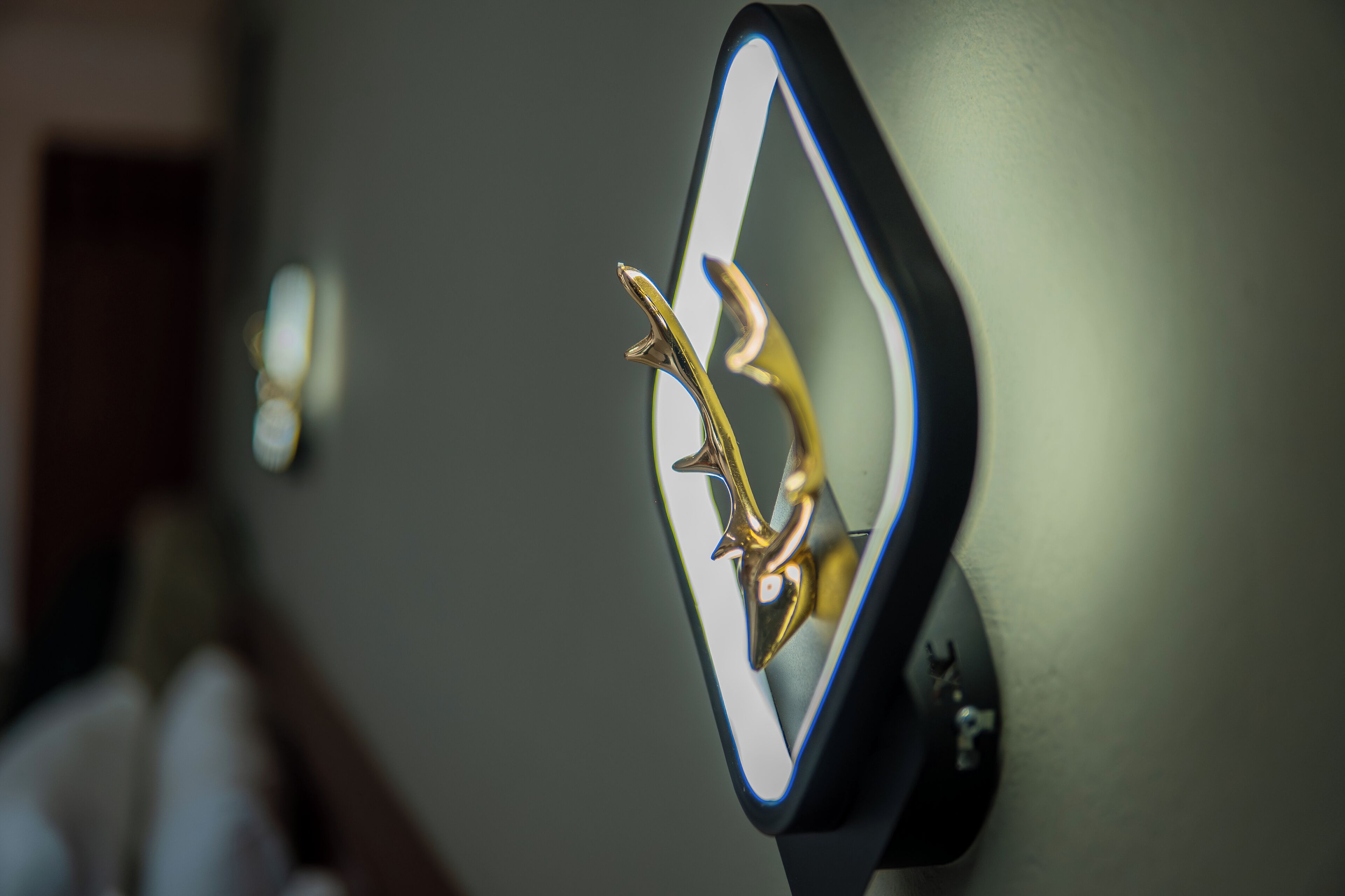 A wall-mounted mirror with a gold decorative element.