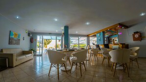 Un vestíbulo de hotel con comedor, bar y vistas al exterior.
