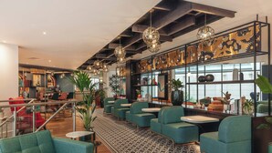 A modern interior with seating, tables, and decorative elements. - Hotel Indigo London Clerkenwell by IHG (London)
