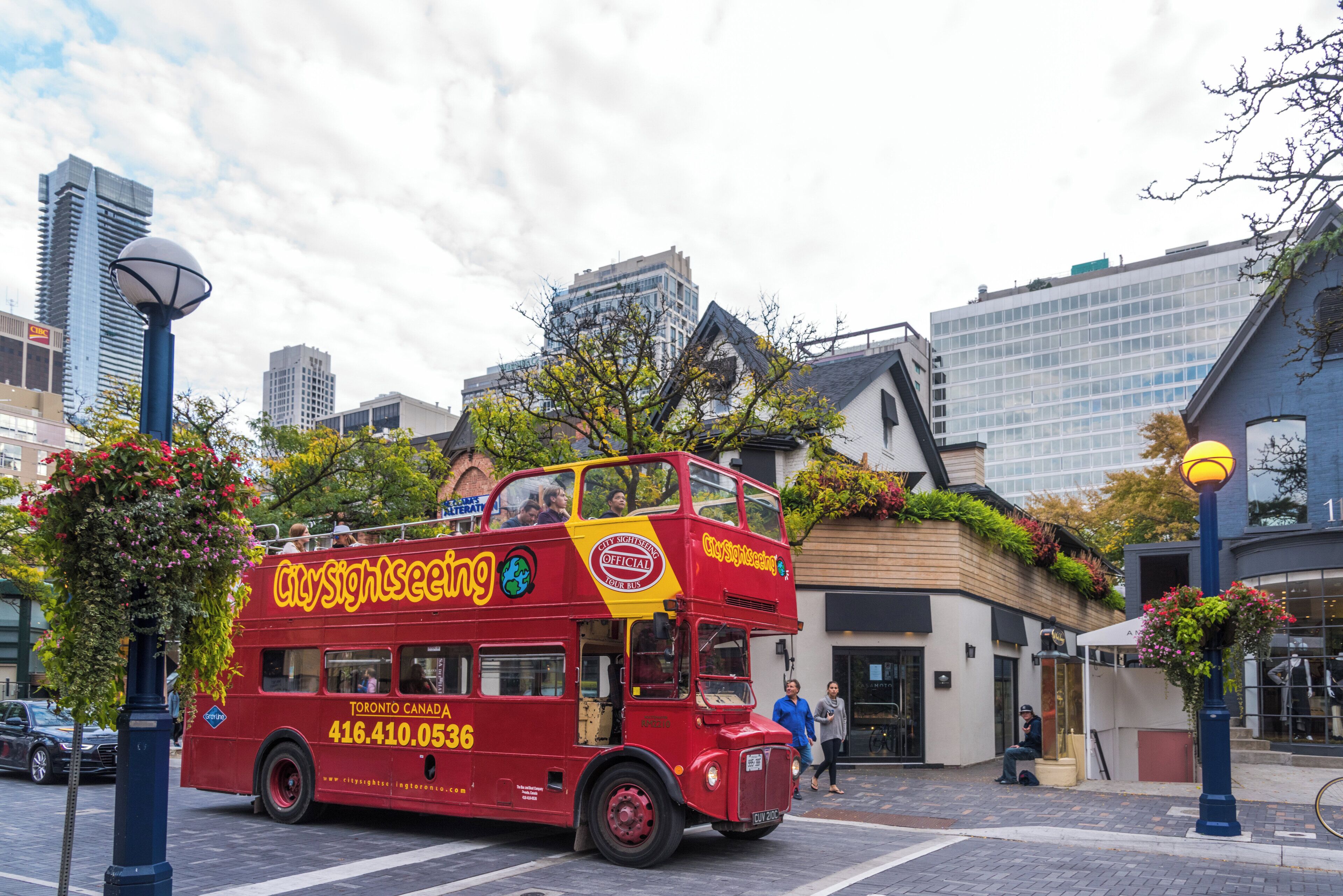 A red double-decker bus with "CitySightseeing" branding and contact number.