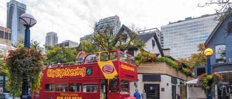 A red double-decker bus with "CitySightseeing" branding and contact number.