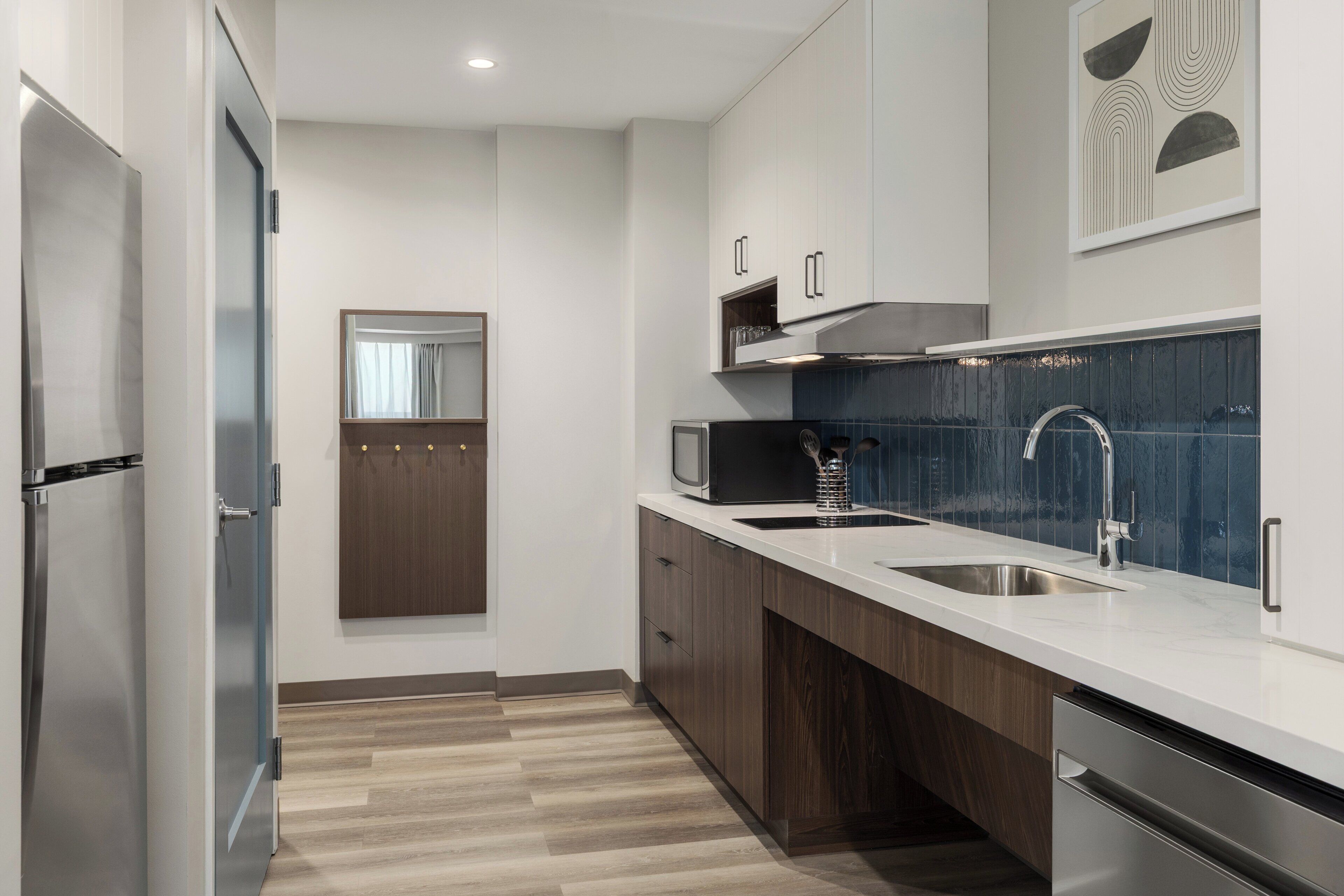 A modern kitchen with stainless steel appliances, a double sink, and wooden cabinets.