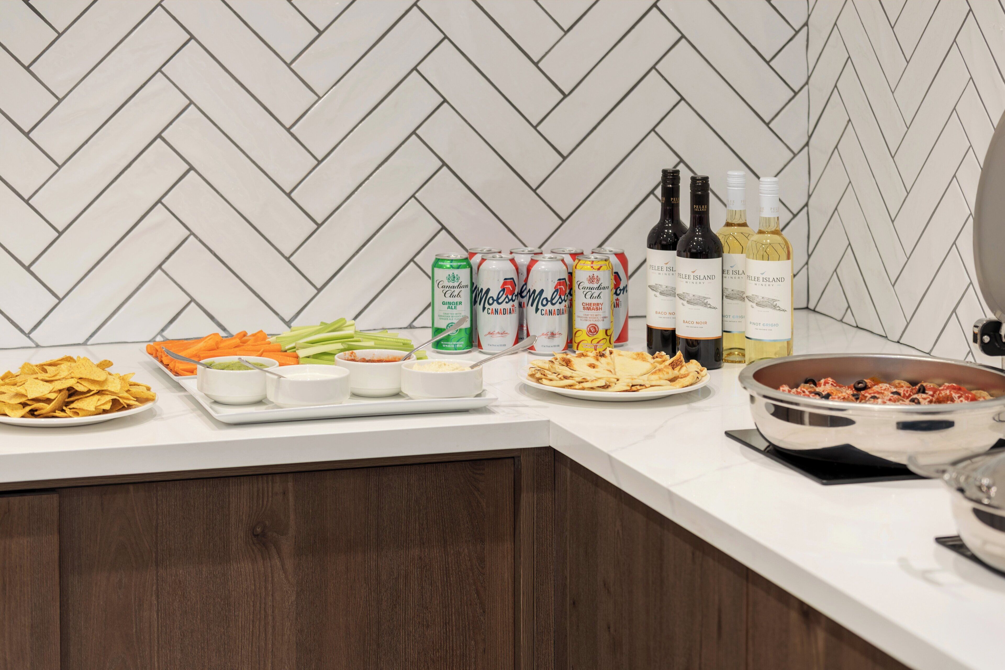A buffet table with various food items, drinks, and condiments.