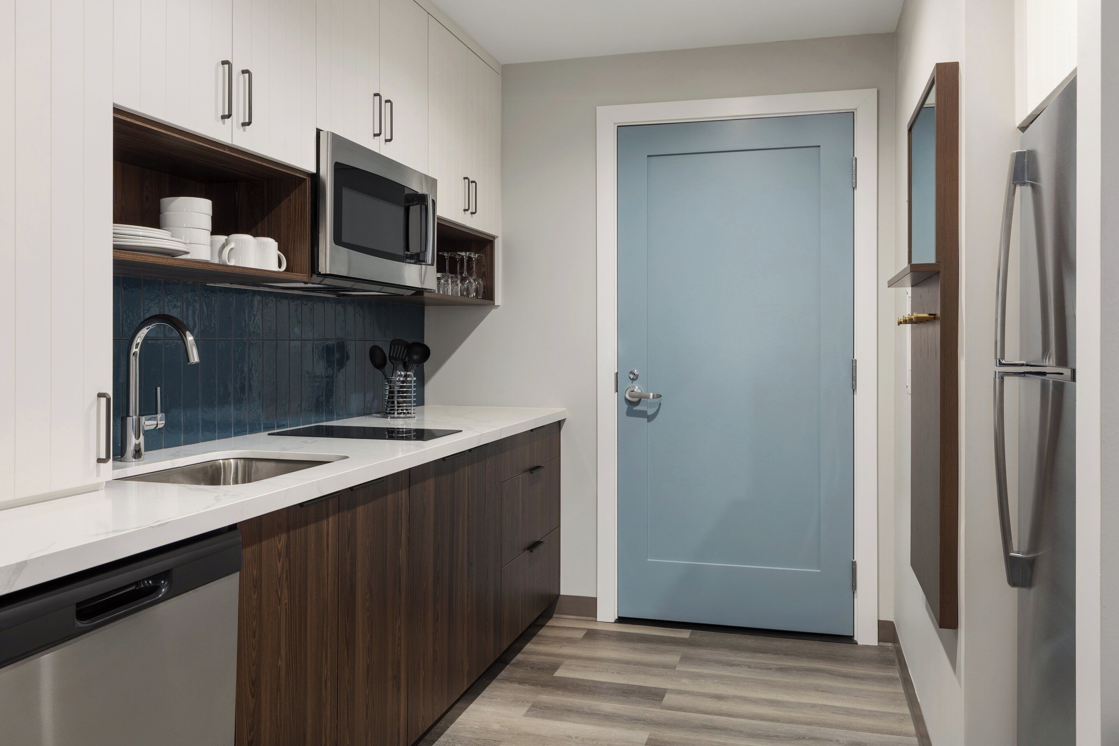 A modern kitchen with a double sink, stainless steel appliances, and wooden cabinets.