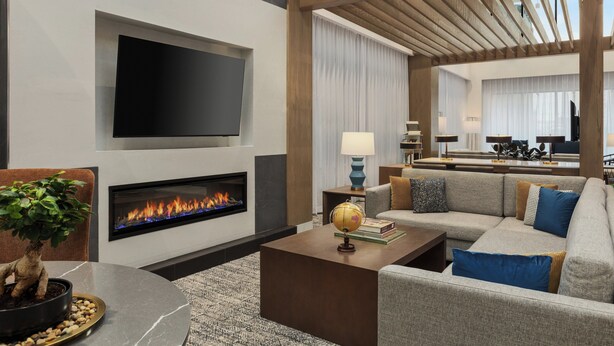 Una sala de estar moderna con chimenea, televisor de pantalla plana, sofá y mesa de centro.