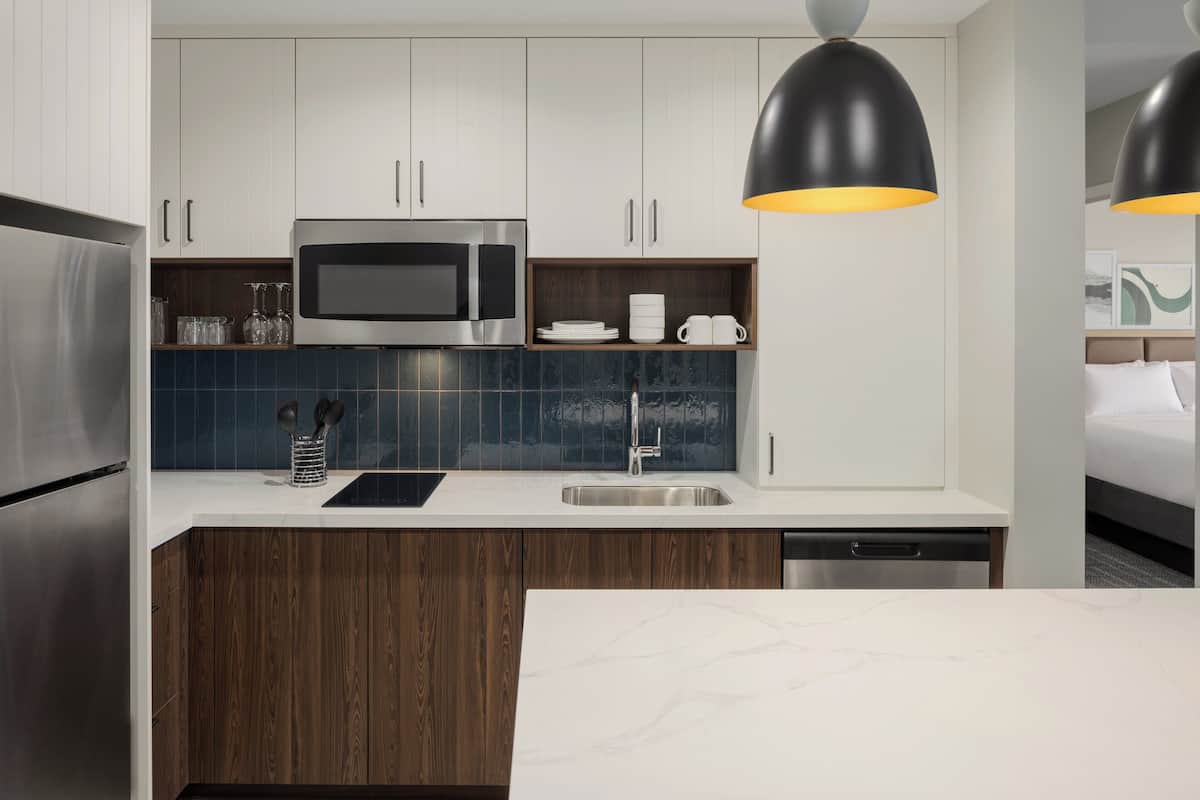 Una cocina moderna con microondas, lavabo y armarios de madera.