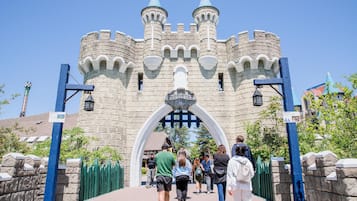 A castle-like structure with a central archway, stone walls, and a clear blue sky.
