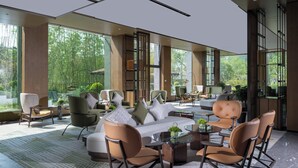 A modern interior with a large window, a sofa set, and a dining table. - Holiday Inn Xuzhou Yunquan by IHG (Xuzhou)