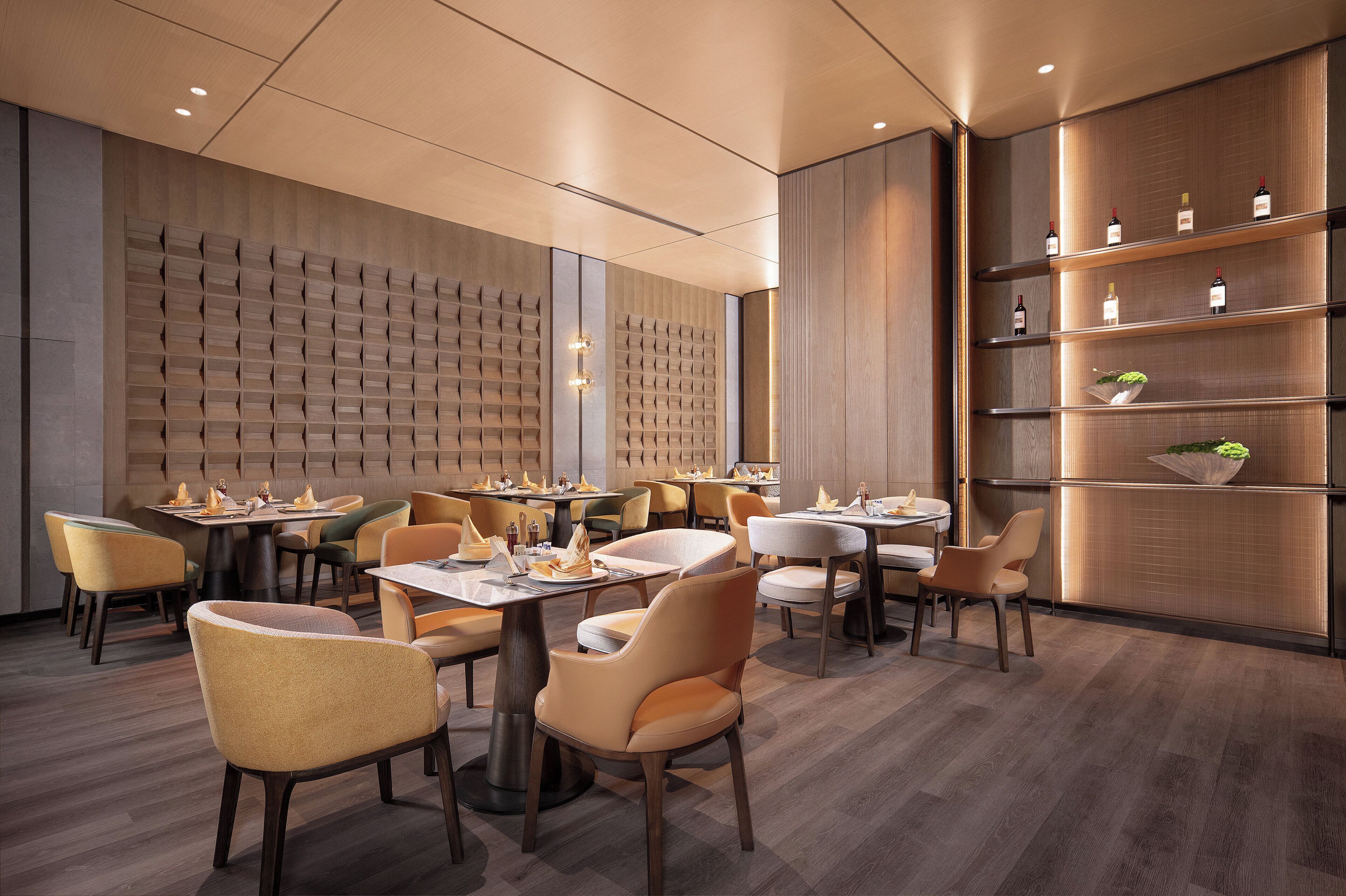 A modern restaurant with wooden panel walls, multiple dining tables, and chairs.