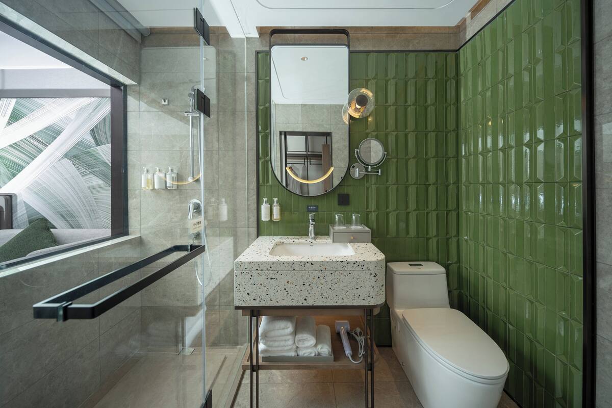 Ein modernes Badezimmer mit Duschkabine aus Glas, einem freistehenden Waschbecken und einer Toilette.
