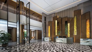 A modern lobby with a geometric patterned floor, a reception desk, and vertical light panels. - Holiday Inn Xuzhou Yunquan by IHG (Xuzhou)