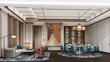 A modern hotel room with a sofa, dining table, chairs, and a large artwork on the wall.