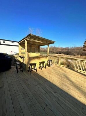 Relax on the deck with a covered seating area and comfortable stools.