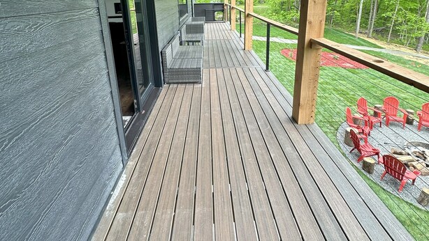 Una terraza cubierta de madera con una parrilla integrada y zona de estar al aire libre.