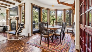 A dining area with a round table, wooden chairs, and a colorful rug. - The perfect place for family and friends to gather for a Rocky Mountain getaway! (Canmore)