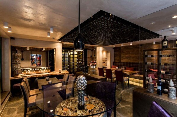 A modern interior with a bar area, seating, and wine racks.