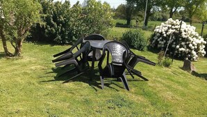 Un espacio al aire libre con césped, una mesa y sillas.