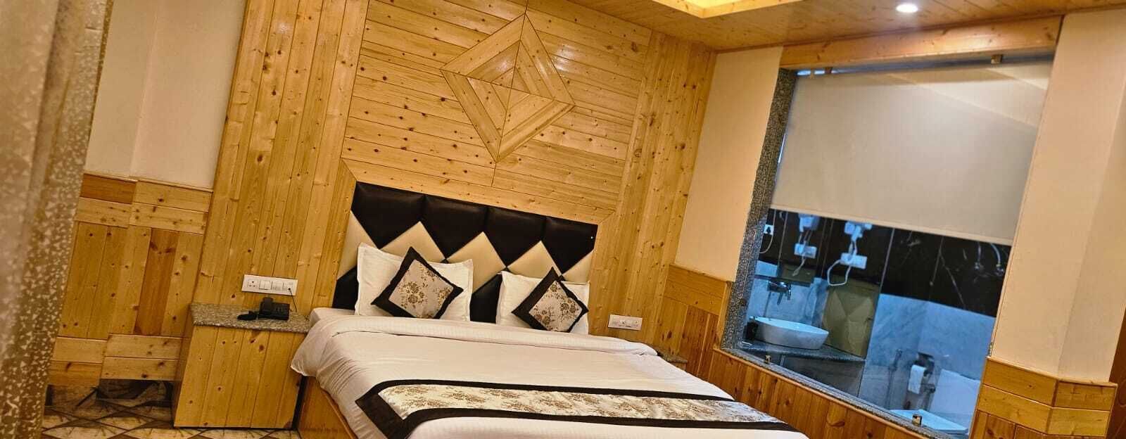 A wooden-paneled bedroom with a bed, a window with a view, and a built-in sink.