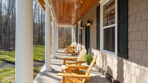 Eine überdachte Veranda mit Holzstühlen und einem Blumentopf.