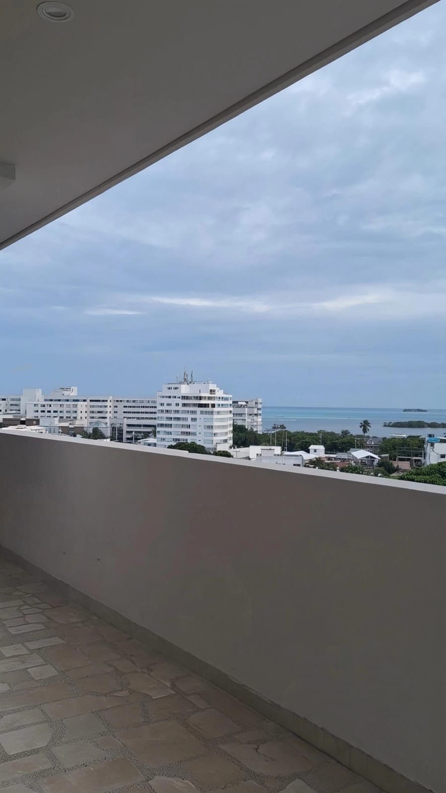 Un balcón con vistas a la ciudad y al mar.