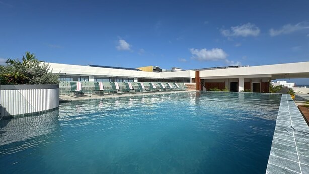 A modern hotel pool area with clear blue water, sun loungers, and a covered seating area. - Zapadilly Tree Hotel (San Andres)
