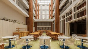 A spacious indoor area with multiple tables and chairs arranged in rows, a central open space, and wooden pillars. - Zapadilly Tree Hotel (San Andres)