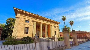 A building with classical architecture, featuring columns and a symmetrical facade. - Appartamenti Pellegrino (Palermo)