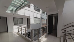 Un interior espacioso y moderno con techos altos, un entrepiso y una escalera.