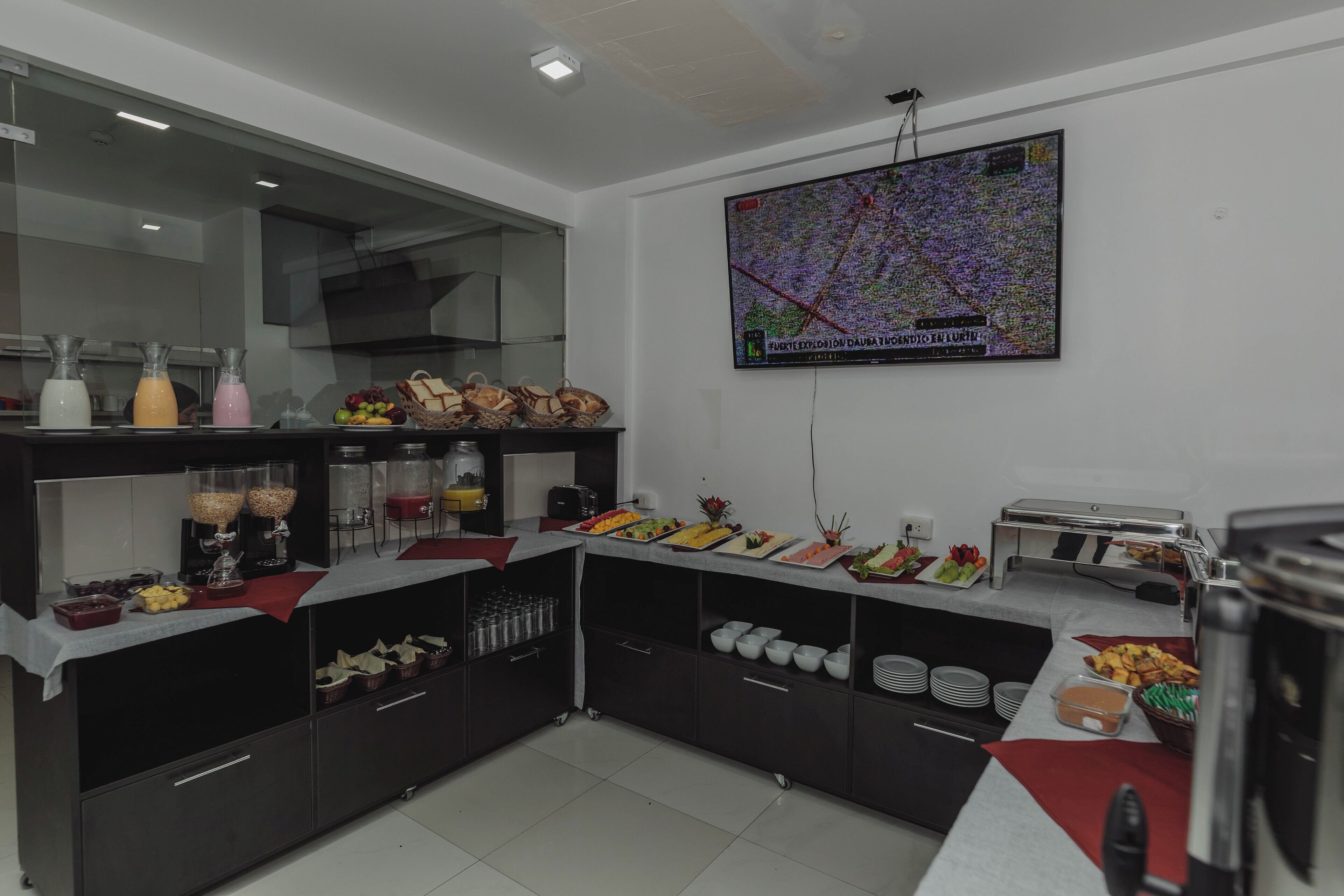 A modern kitchen with a buffet setup, including various food items and beverages.