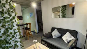 Un salon moderne avec un canapé, une table basse et un luminaire suspendu.