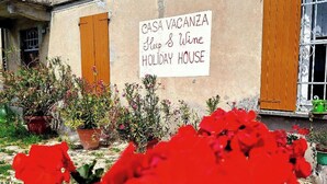 Un bâtiment sur lequel on peut lire l’inscription suivante : « CASA VACANZA, Keep & Wine, MAISON DE VACANCES ».