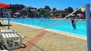 Un espace piscine avec des chaises longues et des parasols.